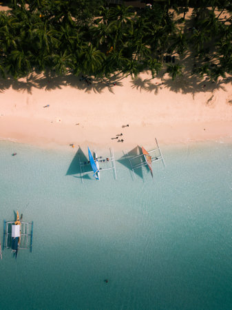 An aerial shot of the boats on the calm crystal clear oceanの写真素材