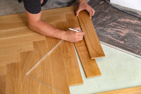 A worker installing wooden laminate flooringの写真素材