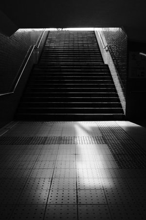 A vertical grayscale shot of a dark staircaseの写真素材