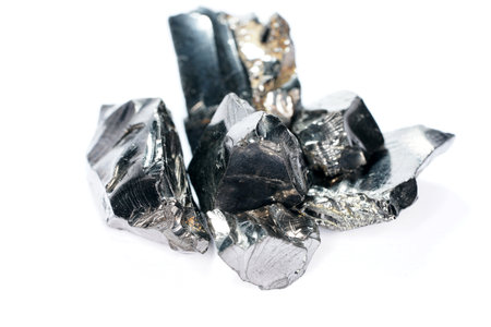 A closeup shot of a shungite mineral isolated on a dark background