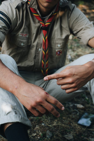 A vertical closeup focus shot of a man sitting in a forest environmentの写真素材