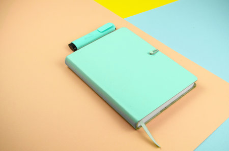 A high angle shot of a green notebook and highlighter - education conceptの写真素材