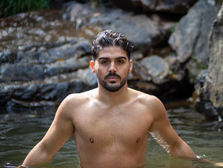A shirtless male Caucasian posing at a riverの写真素材