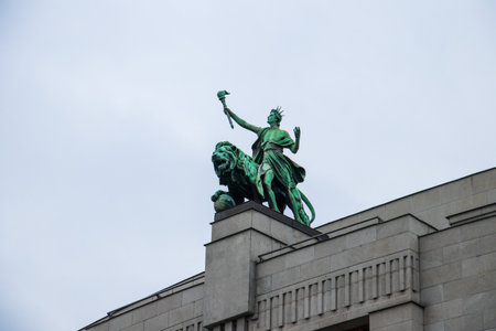 A low angle shot of the lion statue on the National Bank of the Czech Republic under a cloudy sky