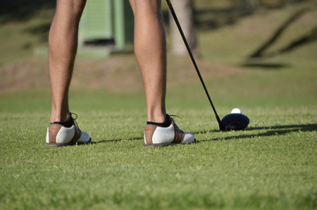 A golfer getting ready to hit the golf ball with a clubの写真素材