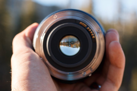 A selective focus shot of a person holding a camera lensの写真素材