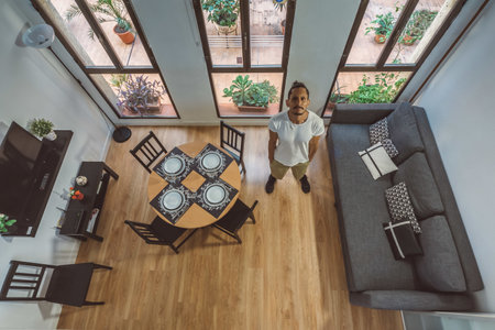 A high angle shot of a living room with a male model