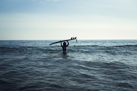 A Caucasian woman during the surfing in the seaの写真素材