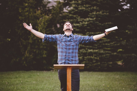 A young male standing and holding the bible in his hands- perfect for oratory, speech, lecturing...