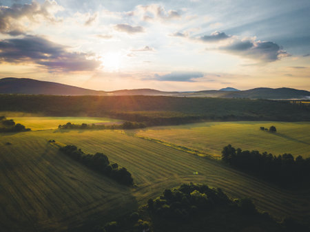 A high angle shot of fields, forests, and hillsの写真素材
