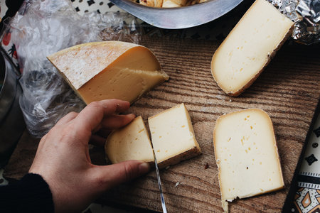 A high angle shot of a person cutting a homemade cheeseの写真素材