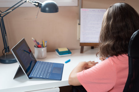 A child doing homework at home with a tabletの写真素材