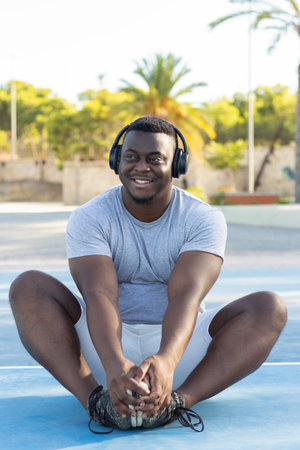 A young black male in headphones working out in a parkの写真素材