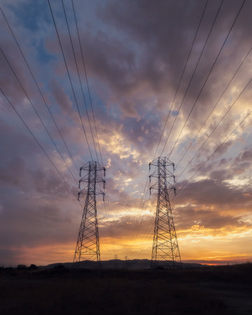 A low angle shot of electricity wires under a beautiful sunset sky