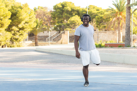 A young black male in headphones working out in a parkの写真素材