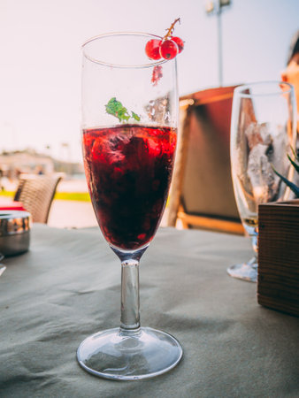 A vertical shot of a berry cocktail on the table under the sunlightの写真素材