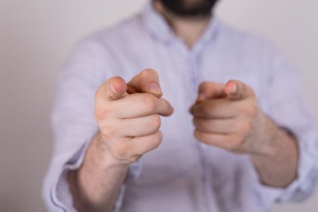 A closeup of a person pointing fingers under the lights on a blurry backgroundの写真素材