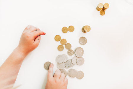 A closeup shot of a hand and coins isolated on white backgroundの写真素材