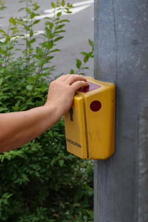 The pedestrian presses the traffic light on the transitionの写真素材