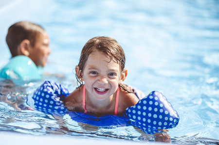 A closeup focus portrait of an adorable little girl swimming in the pool