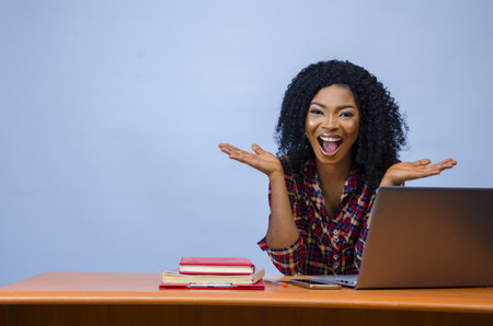 A pretty Afro-American female sitting in front of a laptop and workingの写真素材