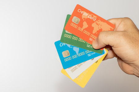 A person holding some colorful credit cards over a white background