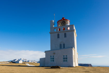 The lighthouse in Dyrholaey under the sunlight and a blue sky in Iceland