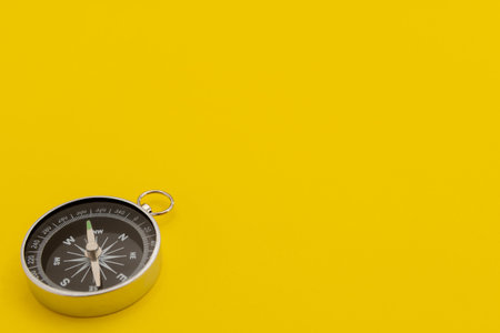 A compass isolated on a yellow backgroundの写真素材