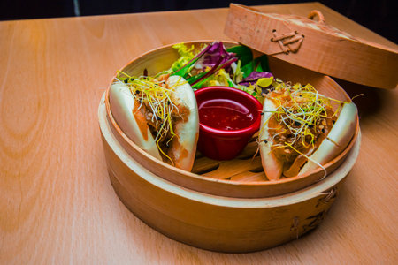 A closeup shot of a delicious traditional Gua bao dish on a streaming basketの写真素材