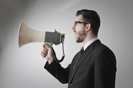 A businessman making an announcement with a loudspeakerの写真素材