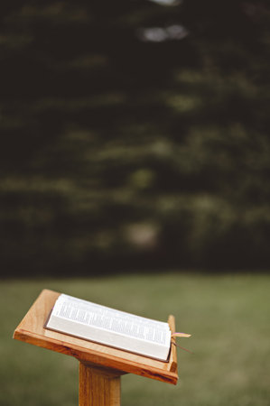 A closeup shot of a wooden speech stand with an opened bookの写真素材