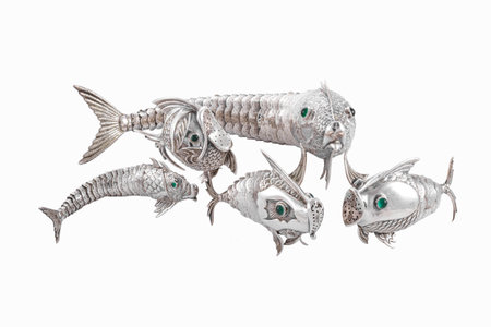 The metal fish statues with green stone eyes isolated on the white backgroundの写真素材