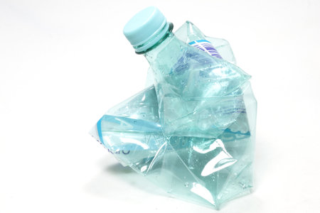 A closeup view of a crashed empty water bottle isolated on a white surfaceの写真素材