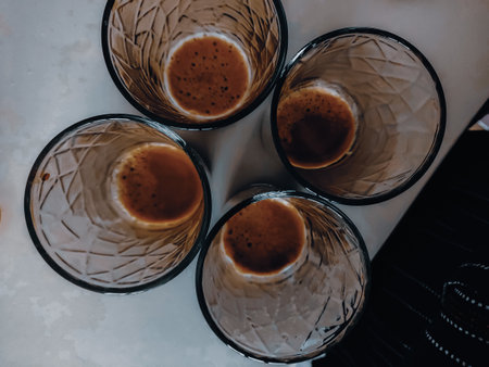 A high angle shot of glass cups filled with some coffee on the bottom