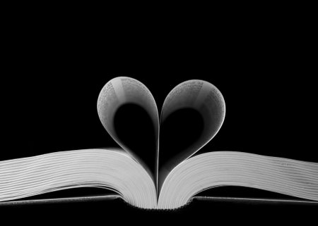 A closeup shot of heart-shaped book pages on a black backgroundの写真素材