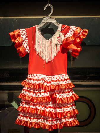 A vertical shot of a hanging orange white flamenco dressの写真素材