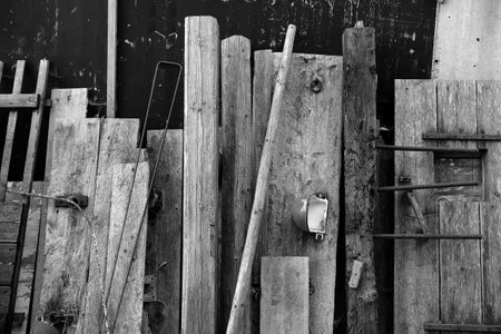 A grayscale shot of old boards and former inventory of a cowshed on a farm in Rudersau, Germanyの写真素材