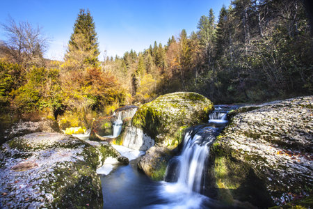 A small mountain waterfall on the rocks in Ain, Franceの写真素材