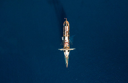 A beautiful aerial top view of a ship in a calm dark seaの写真素材