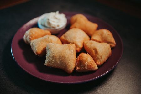 A closeup shot of fresh fried salted baursakis with a sauceの写真素材