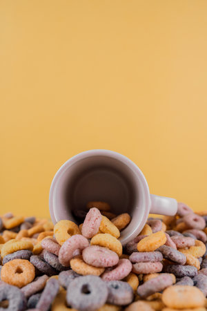 A vertical shot of a colorful cereal spilling out of a coffee cupの写真素材