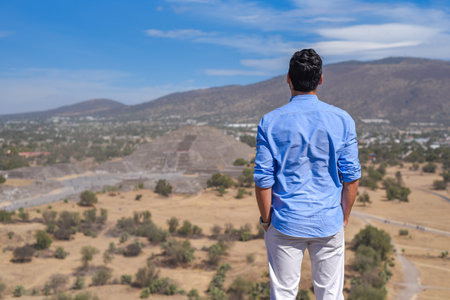 A back view of a man standing on the background of San Juan Teotihuacanの写真素材