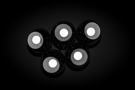A worm's eye view of a modern ceiling lamp with dim light in a dark room