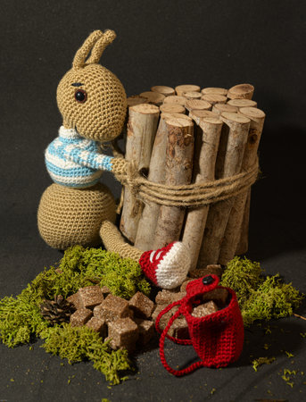 A cute knitted toy bunny with a small bundle of firewood - perfect for easter decorationsの写真素材