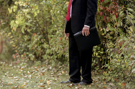 A selective focus shot of a groom surrounded by greeneryの写真素材