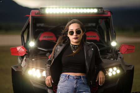 A cool young female leaning on her off-road car