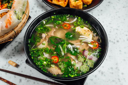A closeup shot of delicious Vietnamese food including Pho ga, noodles, spring rolls on white backgroundの写真素材