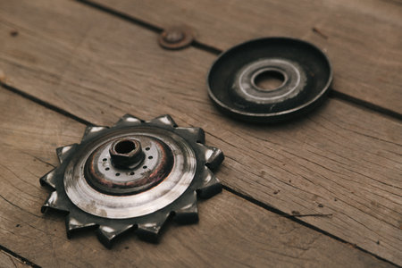 A closeup of greasy bicycle sprocket on a wooden floor