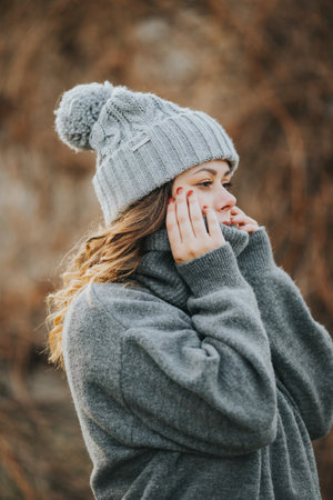 A young Caucasian woman wearing a gray sweater and winter hat - winter conceptの写真素材