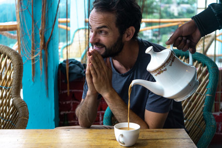 A young caucasian man showing gratitude for the teaの写真素材